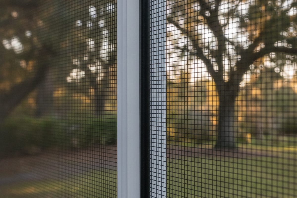 Close view of fiberglass screen mesh set into an aluminum enclosure channel